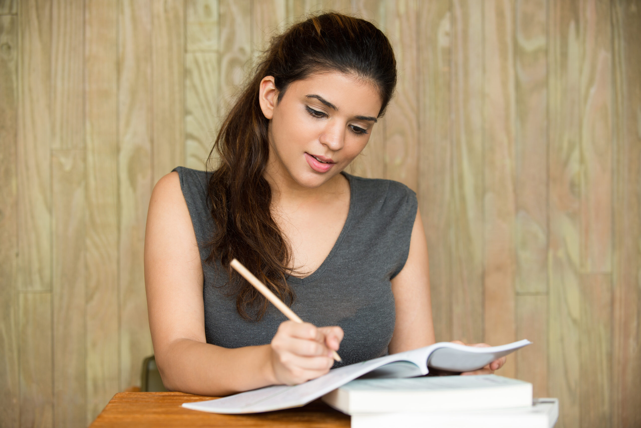 portrait of smiling student writing in classroom